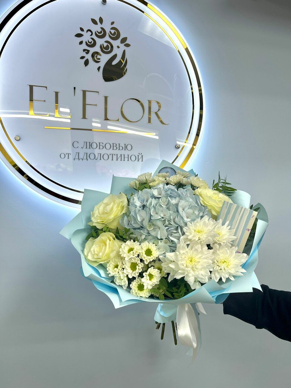 Букет на фоне вывески El'Flors